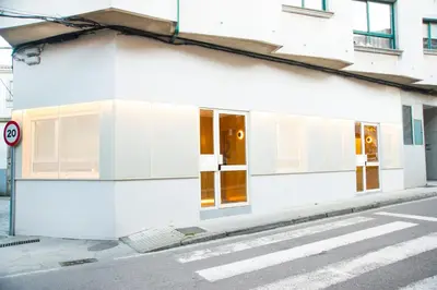 a white building on the side of a street at KALIDAS HOSTEL SUITES in Caldas de Reis