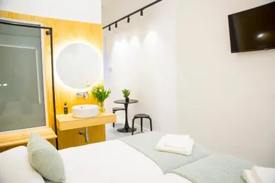 a bedroom with a bed and a sink and a tv at KALIDAS HOSTEL SUITES in Caldas de Reis