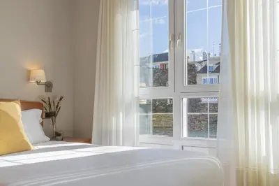 a bedroom with a bed and a large window at Hostal ALBA Lugo in Lugo
