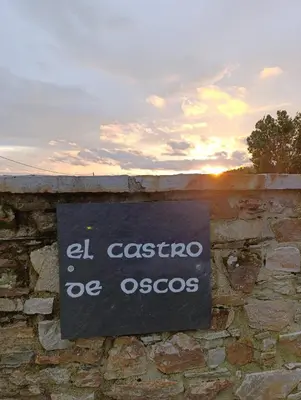 a group of benches sitting outside of a brick building at El Castro de Oscos in Murias