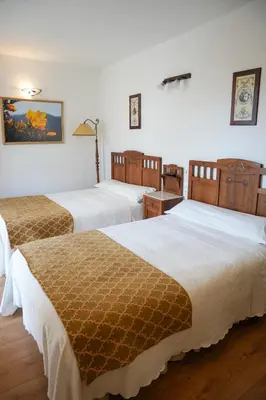 a hotel room with two beds in a room at Hotel Rústico Fonteverde in Cuntis