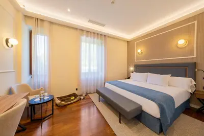 a hotel room with a large bed and a table at Iberik Gran Balneario de Guitiriz in Guitiriz