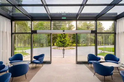 a room with blue chairs and tables and glass doors at Iberik Gran Balneario de Guitiriz in Guitiriz