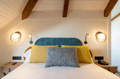 a bedroom with a bed with two lights on the wall at Iberik Gran Balneario de Guitiriz in Guitiriz
