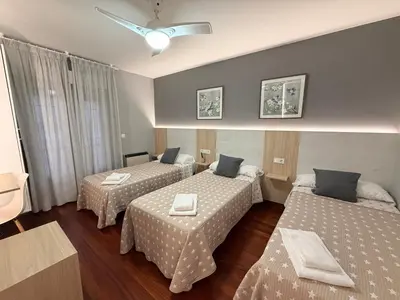a bedroom with two beds and a window at Pensión Atenea & Via Romana - Grupo Arcanos in Caldas de Reis