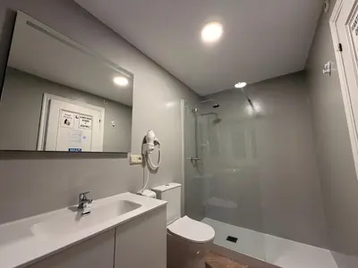 a small room with two beds and a flat screen tv at Pensión Atenea & Via Romana - Grupo Arcanos in Caldas de Reis