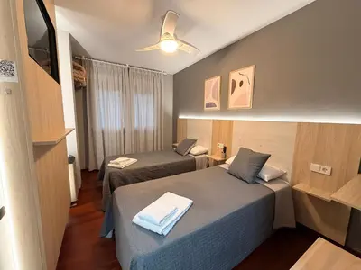 a group of three beds in a room at Pensión Atenea & Via Romana - Grupo Arcanos in Caldas de Reis