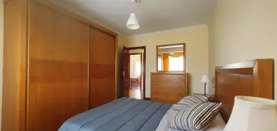 a bedroom with a blue bed and a wooden closet at Apartamento A Pampillosa in Fazouro