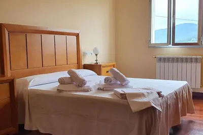 a bedroom with a large bed with towels on it at Apartamento A Pampillosa in Fazouro