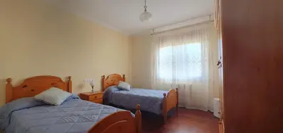 a small bedroom with two beds and a window at Apartamento A Pampillosa in Fazouro