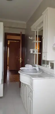 a white bathroom with a sink and a mirror at Apartamento A Pampillosa in Fazouro