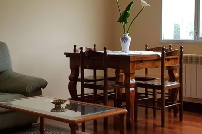a living room with a table and chairs with a vase at Apartamento A Pampillosa in Fazouro