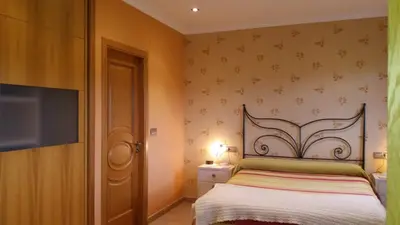 a bedroom with a bed and a flat screen tv at Casa Aida in Foz