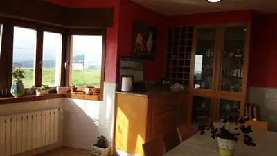 a kitchen with red walls and a counter with windows at Casa Aida in Foz