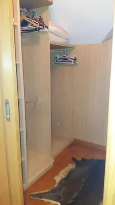 a closet with wooden shelves and a rug on the floor at Casa Aida in Foz