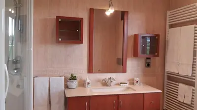 a bathroom with a sink and a mirror and a shower at Casa Aida in Foz