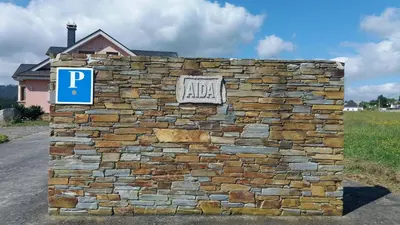 a stone wall with a parking sign on it at Casa Aida in Foz