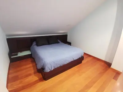 a bed in a small room with a wooden floor at Casa Aida in Foz