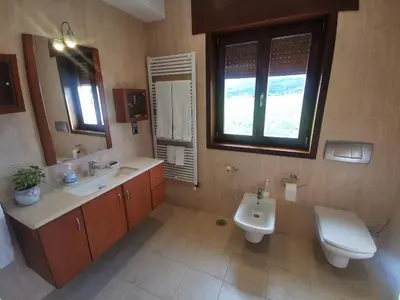 a bathroom with two sinks and a toilet and a mirror at Casa Aida in Foz
