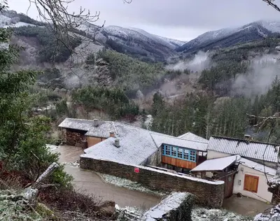 a house in the mountains with snow on the roof at Sons do Eo- Apartamentos ecológicos en la montaña de Lugo in Baleira