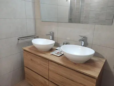 a bathroom with two white sinks on a wooden counter at Armada Sacra A Teixeira in Ourense