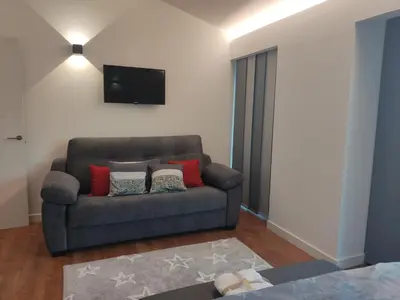 a living room with a couch and a flat screen tv at Armada Sacra A Teixeira in Ourense
