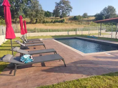 a group of chairs and umbrellas next to a pool at Armada Sacra A Teixeira in Ourense