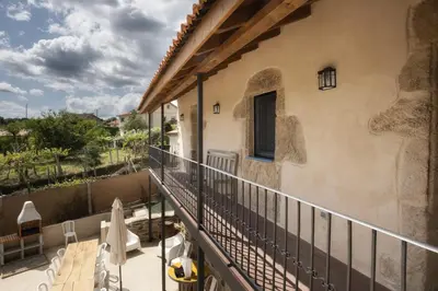 a balcony of a house with chairs and a railing at A Casa da Fonte Azul in Ourense