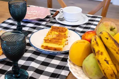 a table topped with a plate of cake and fruit at A Casa da Fonte Azul in Ourense