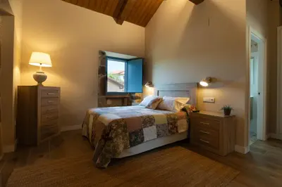 a bedroom with a bed and a dresser and a mirror at A Casa da Fonte Azul in Ourense