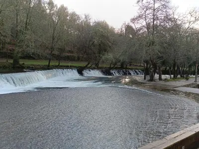 a waterfall in a park next to a body of water at 4 Soles in Puente Caldelas