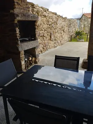 a table in a stone building next to a stone wall at Casa Xulián in Monterroso