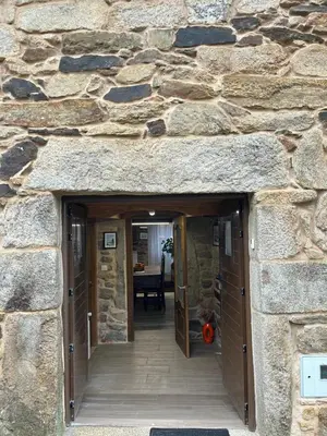 a stone building with a hallway leading to a dining room at Casa Xulián in Monterroso