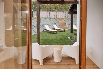 a room with two white chairs and a patio at Yuhom, casas con alma, Xacedos 1 in Miño