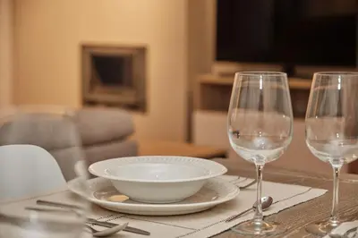 a table with two wine glasses and a bowl on it at Yuhom, casas con alma, Xacedos 1 in Miño