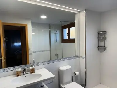 a bathroom with a sink and a toilet and a mirror at Yuhom, casas con alma, Xacedos 1 in Miño
