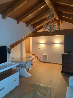 a living room with a chandelier and a table and a couch at Agarimo das Burgas in Ourense