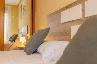 a bedroom with a bed with two pillows on it at Apartagal-Costa Reinante Spa in Barreiros