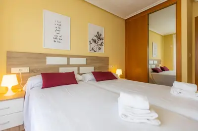 a bedroom with a large white bed with red pillows at Apartagal-Costa Reinante Spa in Barreiros
