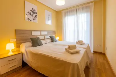 a bedroom with a large bed with two towels on it at Apartagal-Costa Reinante Spa in Barreiros