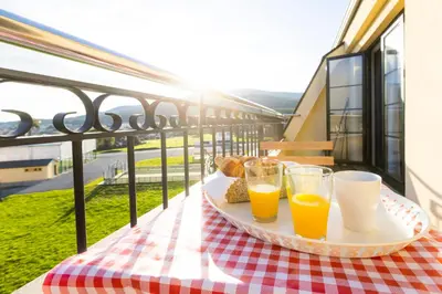 a tray with two glasses of orange juice on a table on a balcony at Apartagal-Costa Reinante Spa in Barreiros
