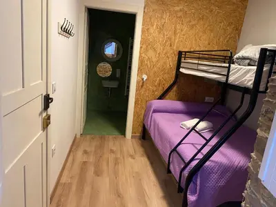 a bedroom with a bunk bed with purple sheets at Albergue O Santo in Arzúa