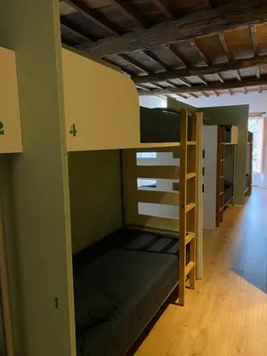 a room with two bunk beds and a hallway at Albergue O Santo in Arzúa