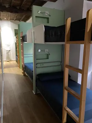 a bunk bed room with two bunk beds and a ladder at Albergue O Santo in Arzúa