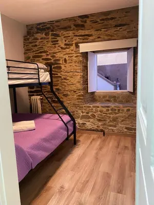 a small room with a bunk bed and a window at Albergue O Santo in Arzúa