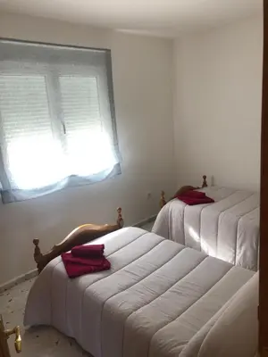 two beds in a room with a window at Casa turismo rural Becar in Corullón