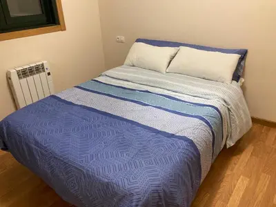 a bed with a blue comforter in a room at FOZ II PLAYAS in Foz