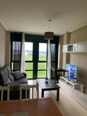 a living room with a couch and a tv at FOZ II PLAYAS in Foz