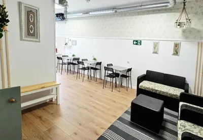 a living room with a couch and tables and chairs at Hostel Bretema in Lugo