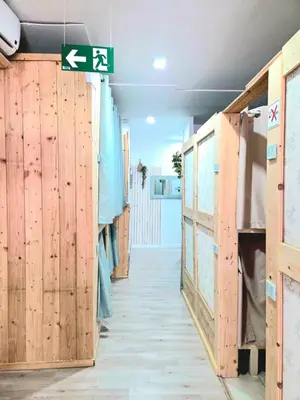 a hallway with wooden doors and a sign on a wall at Hostel Bretema in Lugo
